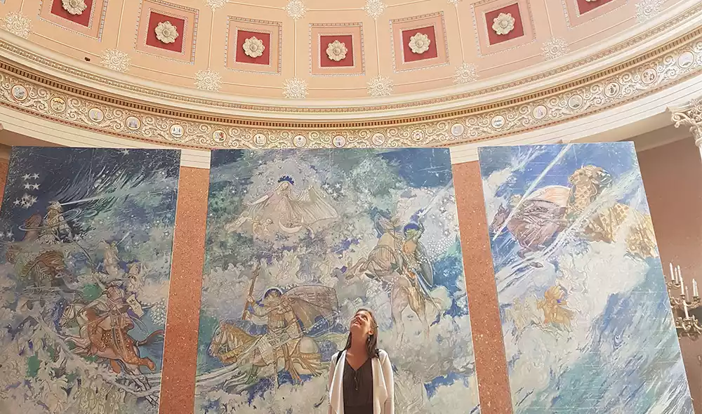 woman in the Dome Room of the Hungarian National Museum, looking up at the ceiling