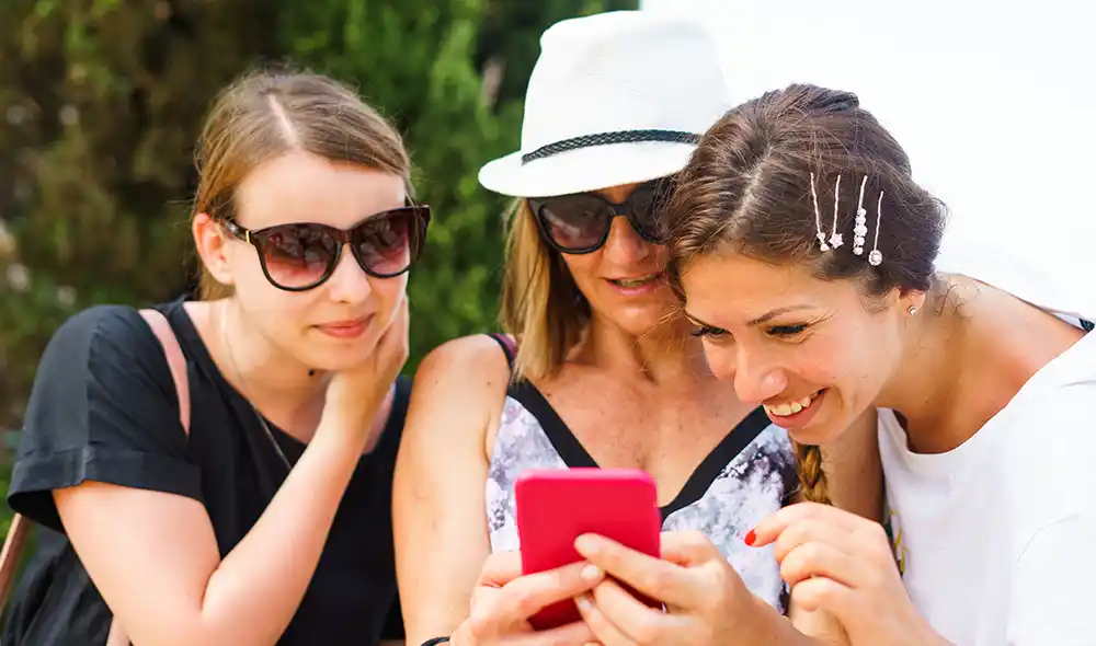 három fiatal nő a Vasúttörténeti Parkban okostelefonnal Landventure nyomozós játékot játszik