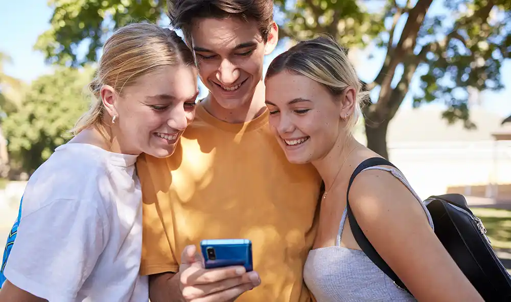 három fiatal a Vasúttörténeti Parkban okostelefonnal Landventure nyomozós játékot játszik