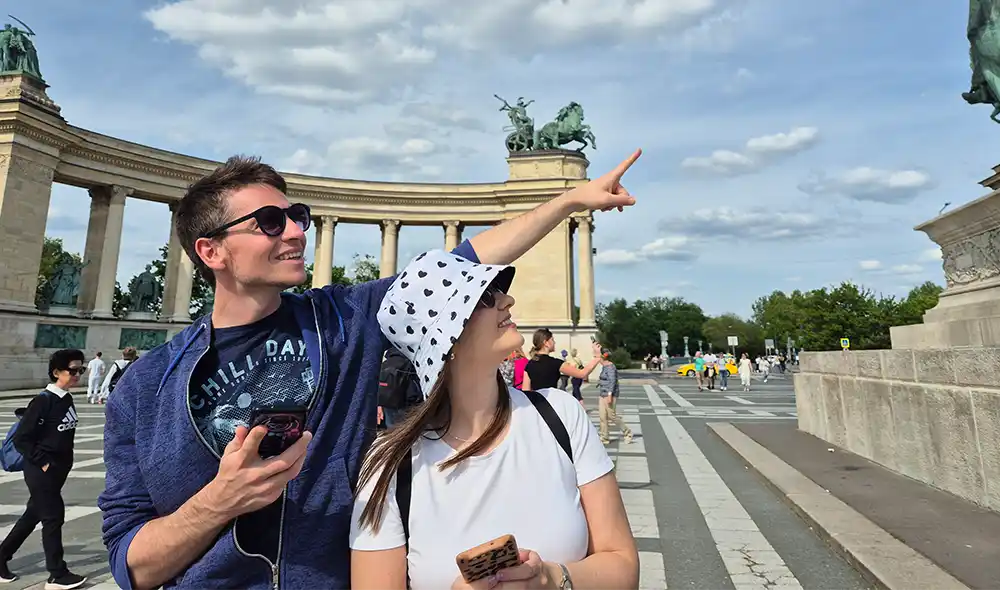 young couple playing a Landventure outdoor escape game in Budapest's City Park and pointing into the distance