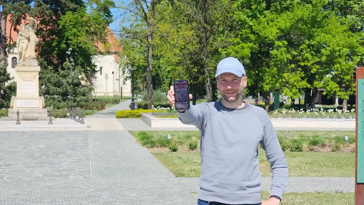 egy férfi a telefonját mutatja, miközben Landventure szabadtéri szabadulós játékot játszik Bükön