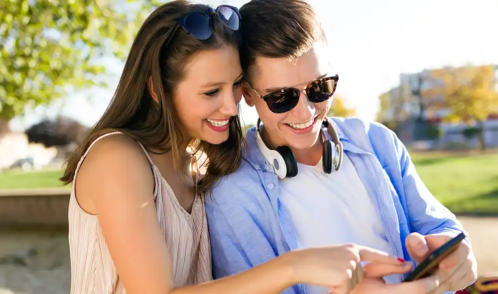 a young couple playing a Landventure outdoor escape game with a smartphone in downtown Debrecen