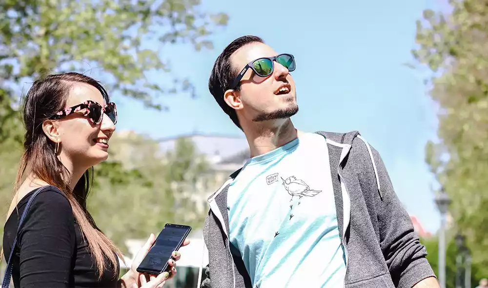 a young couple is looking into the distance with joy and curiosity in downtown Esztergom while playing an adventure game