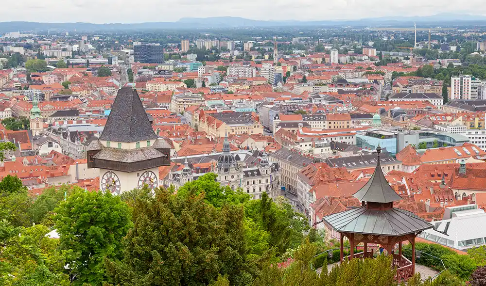 View of Graz with the clock tower on the Schlossberg and the red rooftops of the old town
