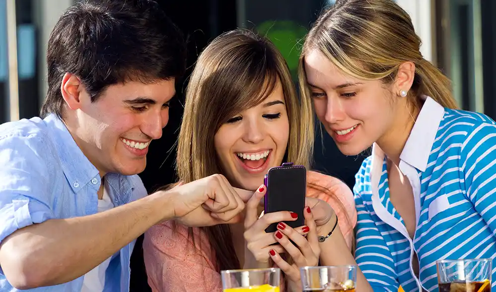 két nő és egy férfi okostelefonnal Landventure szabadtéri szabadulós játékot játszik Győr belvárosában