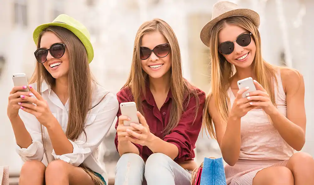 three women participating in a Landventure scavenger hunt in Mödling using their smartphones