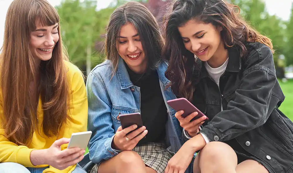 drei junge Frauen nehmen in München an einer Landventure Stadtrallye-Schnitzeljagd mit dem Smartphone teil