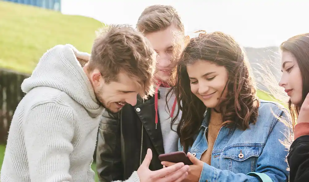 eine Gruppe junger Leute nimmt in München an einer Landventure Stadtrallye-Schnitzeljagd mit dem Smartphone teil