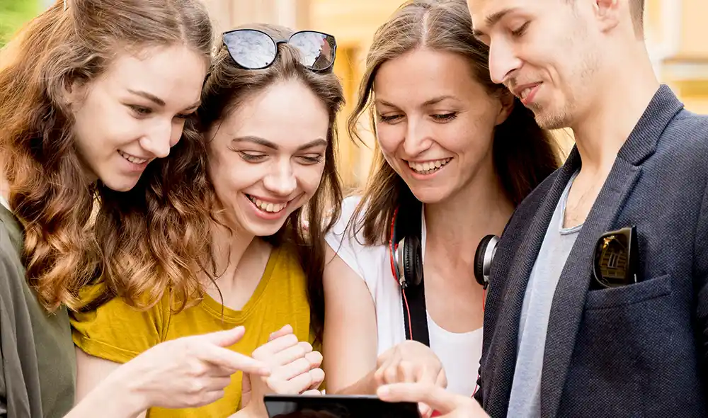 three women and a man are enjoying an exciting Landventure outdoor escape game in Salzburg and exploring the city center