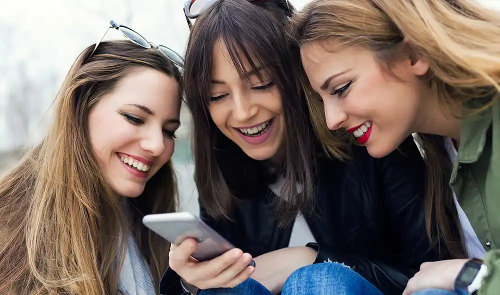 three women are taking part in a Landventure scavenger hunt in Salzburg using their smartphones