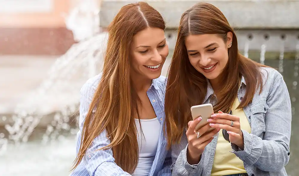 two women taking part in an exciting Landventure scavenger hunt in Salzburg using their smartphone