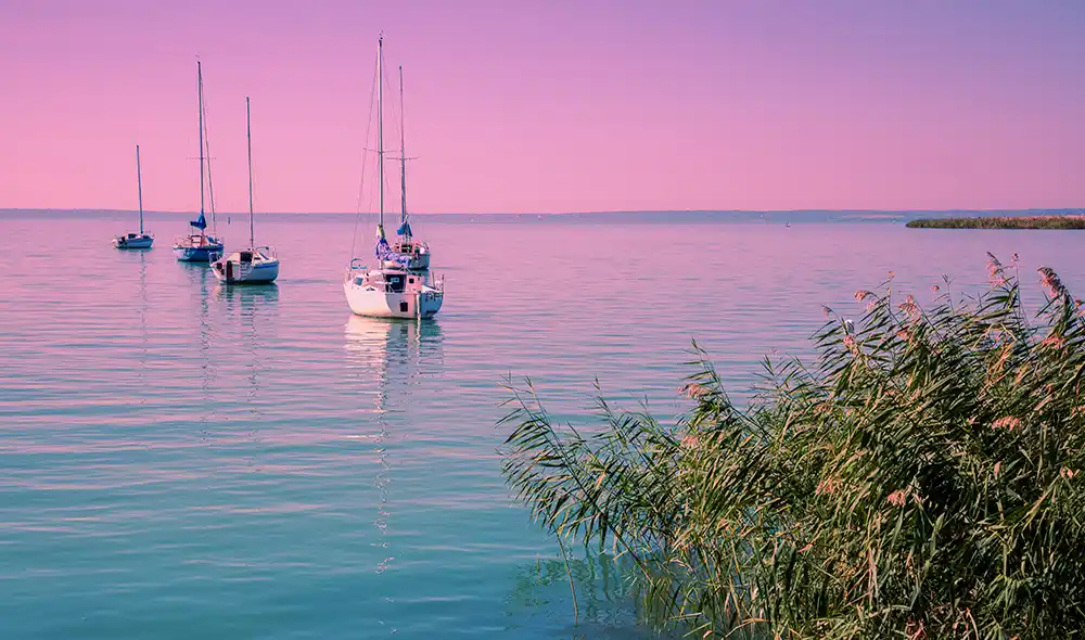 Balaton látképe naplementében hajókkal Siófok partjánál 