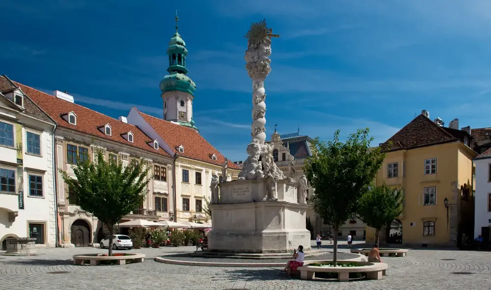 Sopron Fő tere a Szentháromság-szoborral és történelmi épületekkel, ahol izgalmas Landventure küldetések játszhatók